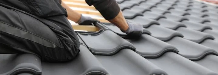 Person befestigt Dachziegel